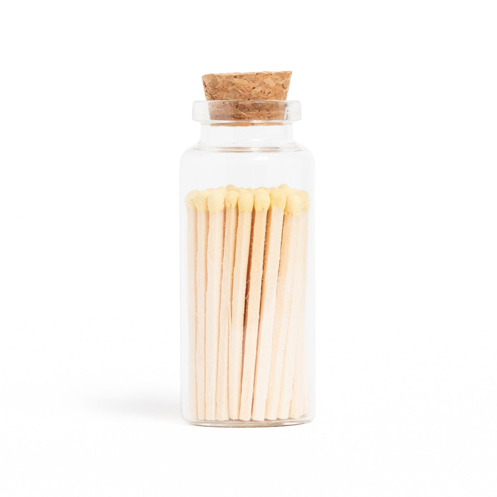 ivory colored matchsticks in corked jar with match striker