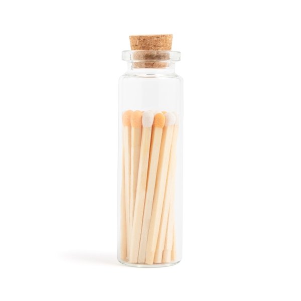 orange cream colored matchsticks in corked jar with match striker