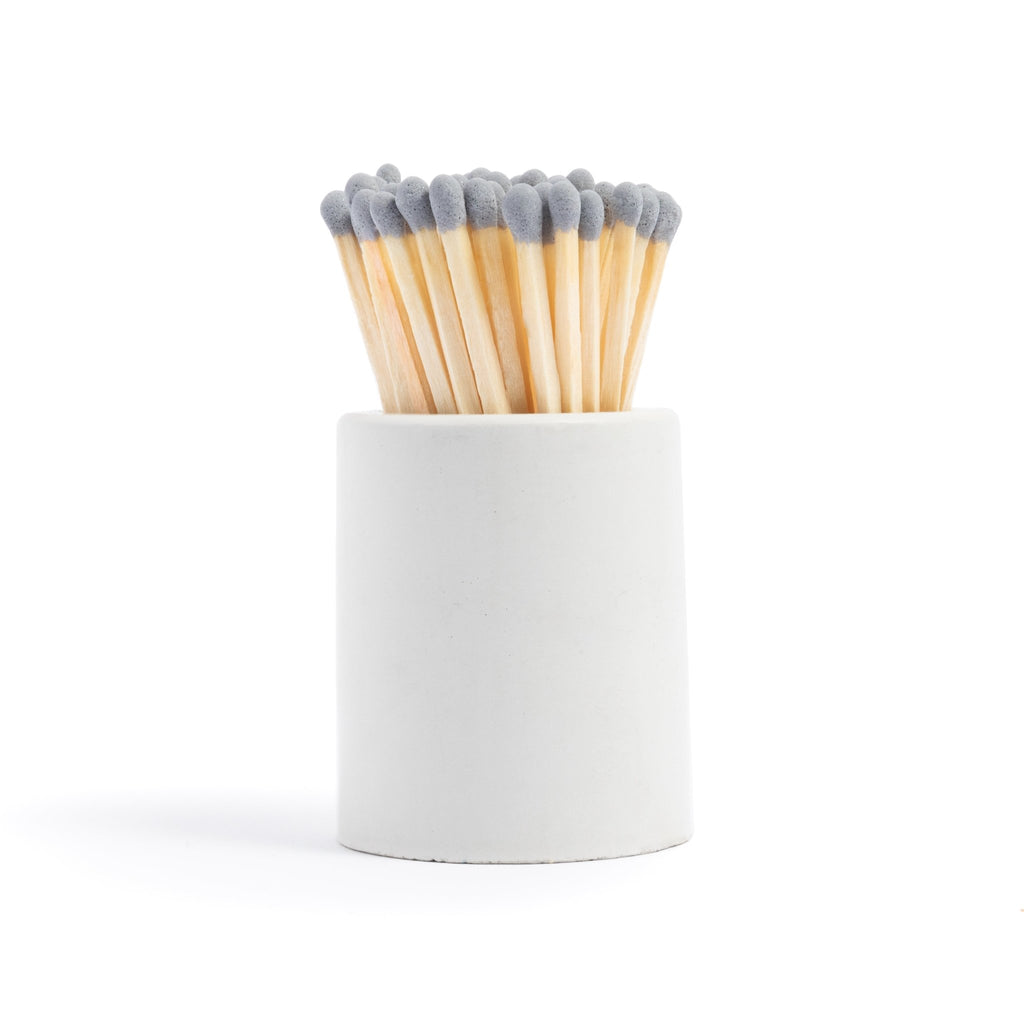 white concrete match jar with colorful matchsticks and match striker