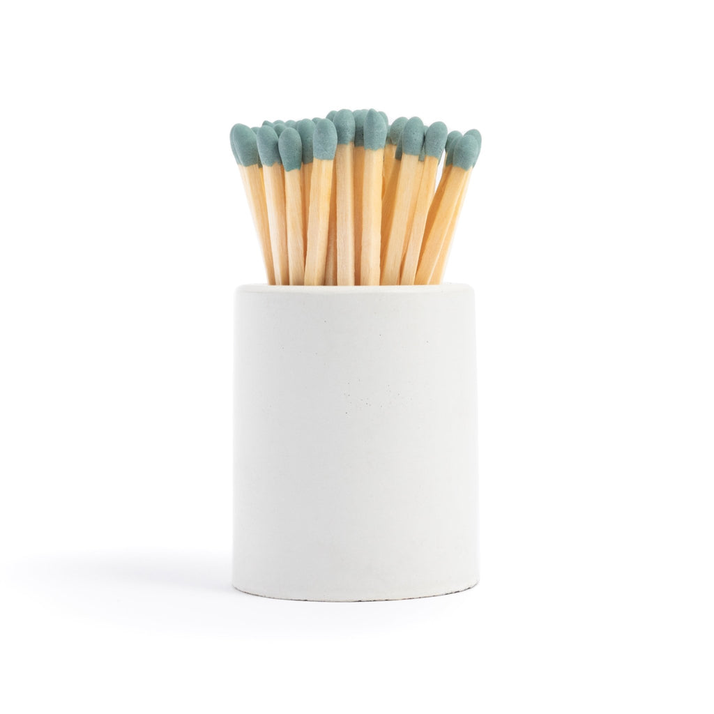 white concrete match jar with colorful matchsticks and match striker