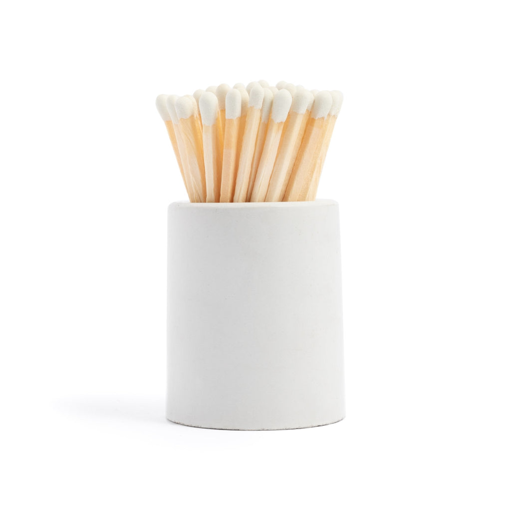 white concrete match jar with colorful matchsticks and match striker