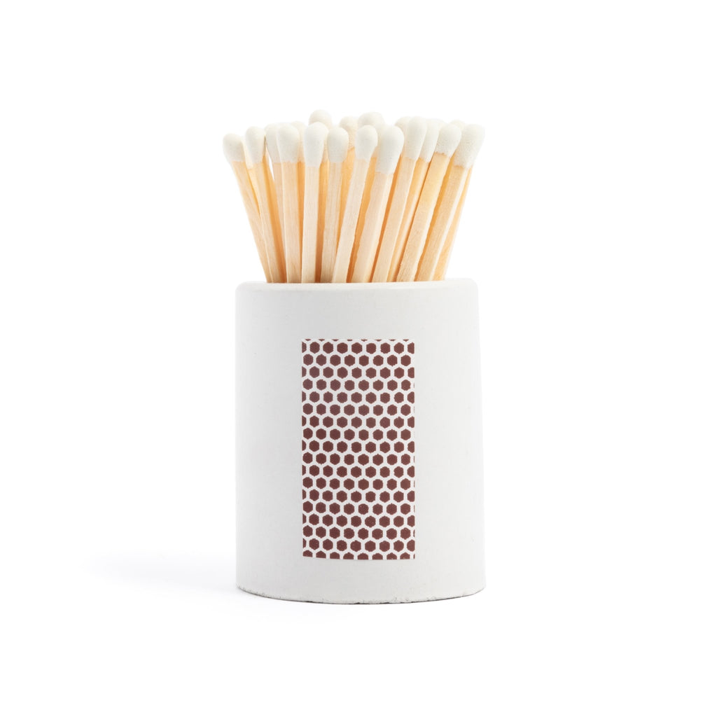 white concrete match jar with colorful matchsticks and match striker